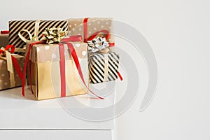 Many gift boxes standing on a white table. Christmas presents