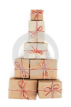 Many gifts in the form of a Christmas tree, a design of craft paper tied with a red and white rope and a bow. Perfect isolate on a