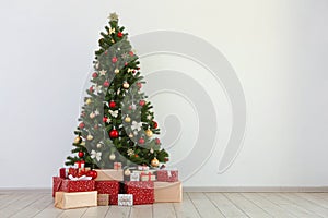 Many gifts under a festively decorated Christmas tree in a bright interior