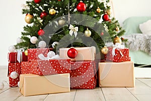 Many gifts under a festively decorated Christmas tree in a bright interior