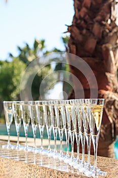 Many glasses of champagne or prosecco near resort pool in a luxury hotel. Pool party.