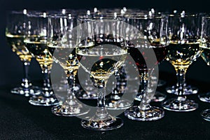 Many glasses of different wine on black bar counter