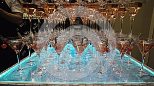 Many glasses for Martini with alcohol are on table in bar. Action. Mountains of wine glasses Martini with alcoholic