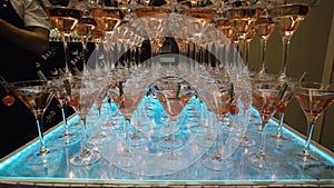 Many glasses for Martini with alcohol are on table in bar. Action. Mountains of wine glasses Martini with alcoholic