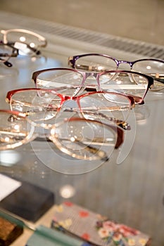 Many glasses rows at optical retail store. Rich assortment choice of different eyewear frames on eyeglasses shop display
