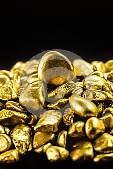 Many gold nuggets on isolated black background, concept of wealth and rare ores