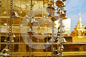 Many golden buddhist bells in sunlight closeup