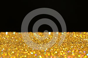 Many golden paillettes against black background