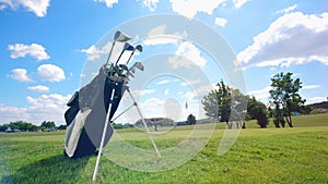 Many golf clubs in a bag at a field. Golf equipment.