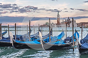 Many gondolas in Venice in Italy at sunset