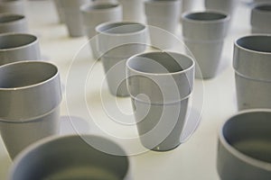 Many gray ceramic cups stand on the table