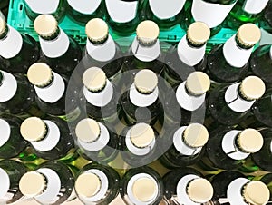 Many green beer bottles in a row, top view