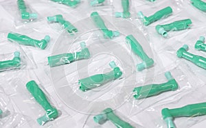 Many Green Disposable Prophy Angles with Brush, Ergonomic Shape on White Background