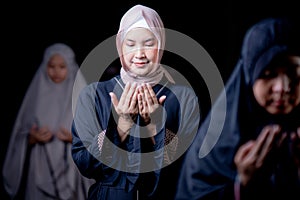 Many groups of Asian Muslim women in the Islamic religion in hijabs of cream and black color. She was praying