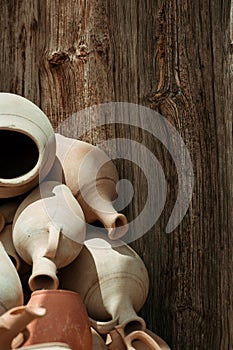 Many handmade old clay pots on the wooden background.