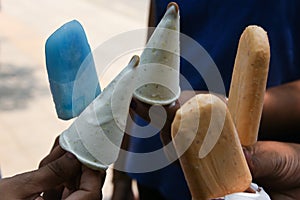 Hand holding kulfi and ice cream stick Delhi India photo