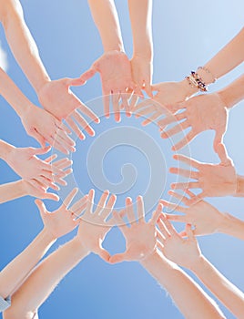 Many hands over blue sky background