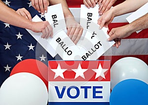 Many hands placing ballots in an election vote box