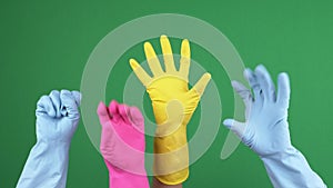 Many hands with protective rubber gloves joyfully clench and unclench their fingers over green chromakey background. 4k