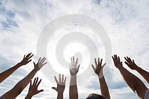 Many hands raised up against the blue sky. Friendship