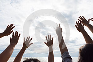 Many hands raised up against the blue sky. Friendship, Teamwork