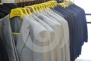 Many hanging suits in a clothing store