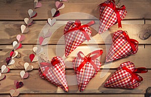 Many hearts sewn from red plaid fabric on the board