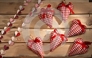 Many hearts sewn from red plaid fabric on the board