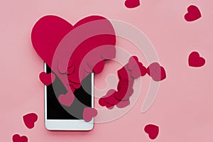 Many hearts and smartphone. The concept to like in social networks or Dating app. pink background