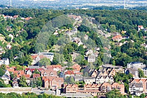 Many houses on a hill among trees. Dense population in the city. A photo taken from a bird`s eye view