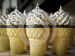 Many ice cream cones on the wooden vintage table conceptual photo