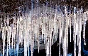 Many icicles hanging from the ceiling of the cave