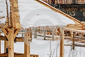 Many icicles melt on the wooden roof with water drops. Spring is comming.