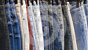 Many jeans hanging on arack. Row of pants denim jeans hanging in closet, concept of buy , sell , shopping and jeans