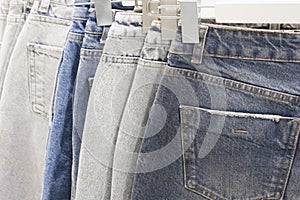 Many jeans hanging on arack. Row of pants denim jeans hanging in closet, concept of buy , sell , shopping and jeans fashion