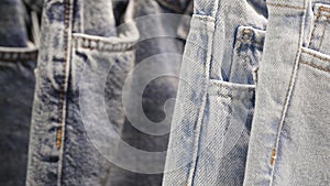 Many jeans hanging on rack. Row of pants denim jeans hanging in closet, concept of buy , sell , shopping and jeans fashion