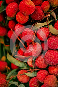 Many juicy red lychee fruits on the market counter.