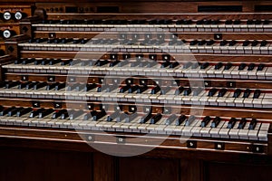 Many keys on a big old brown church organ