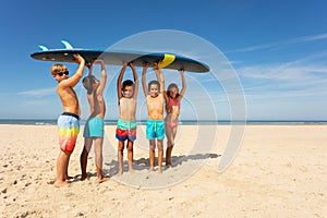Many kids carry surfboard on the beach to sea