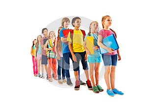 Many kids standing in line with books