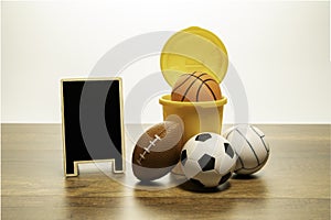 Many kind of balls and yellow basket with blank black board