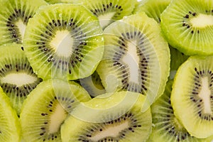 Many kiwi slices are placed in a glass crisper. Kiwifruit slices without peel