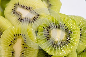 Many kiwi slices are placed in a glass crisper. Kiwifruit slices without peel