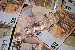 Many Krugerrand and Dollar gold coins are lying on various spread out Euro banknotes