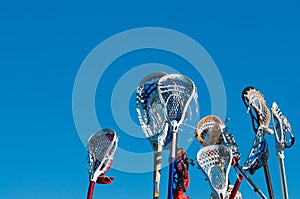 Many lacrosse sticks in the air