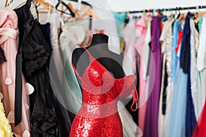 Many ladies evening gown long dresses on hanger in the dress rent shop for the wedding day or photo session. Dresses