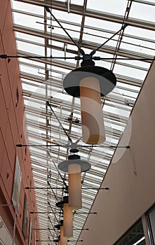 Many lamps hang on the ceiling of the mall. Interior. Electricity.