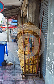 Many large baskets are stacked on Hand Trolley With 2 Solids Wheels on a footpath in Bangkok, Thailand