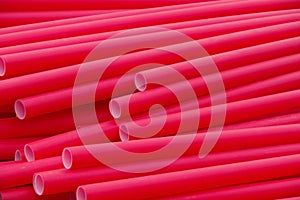 Many long red industrial plastic pipe