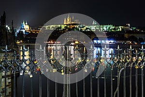 Many Love locks on the fence, heart padlock on the Charles Bridge in Prague's Hradcany blured background